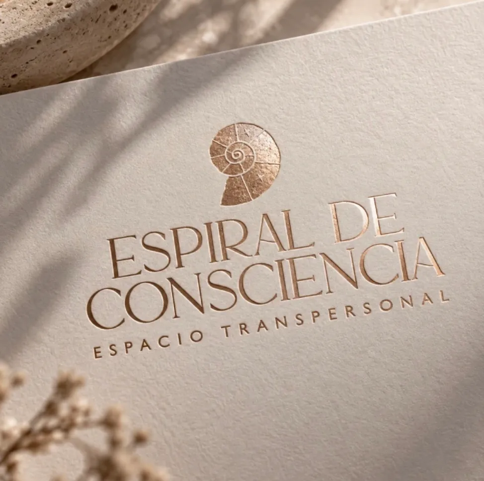 Espiral de Consciencia logo with its spiral shell, in gold foil on textured paper