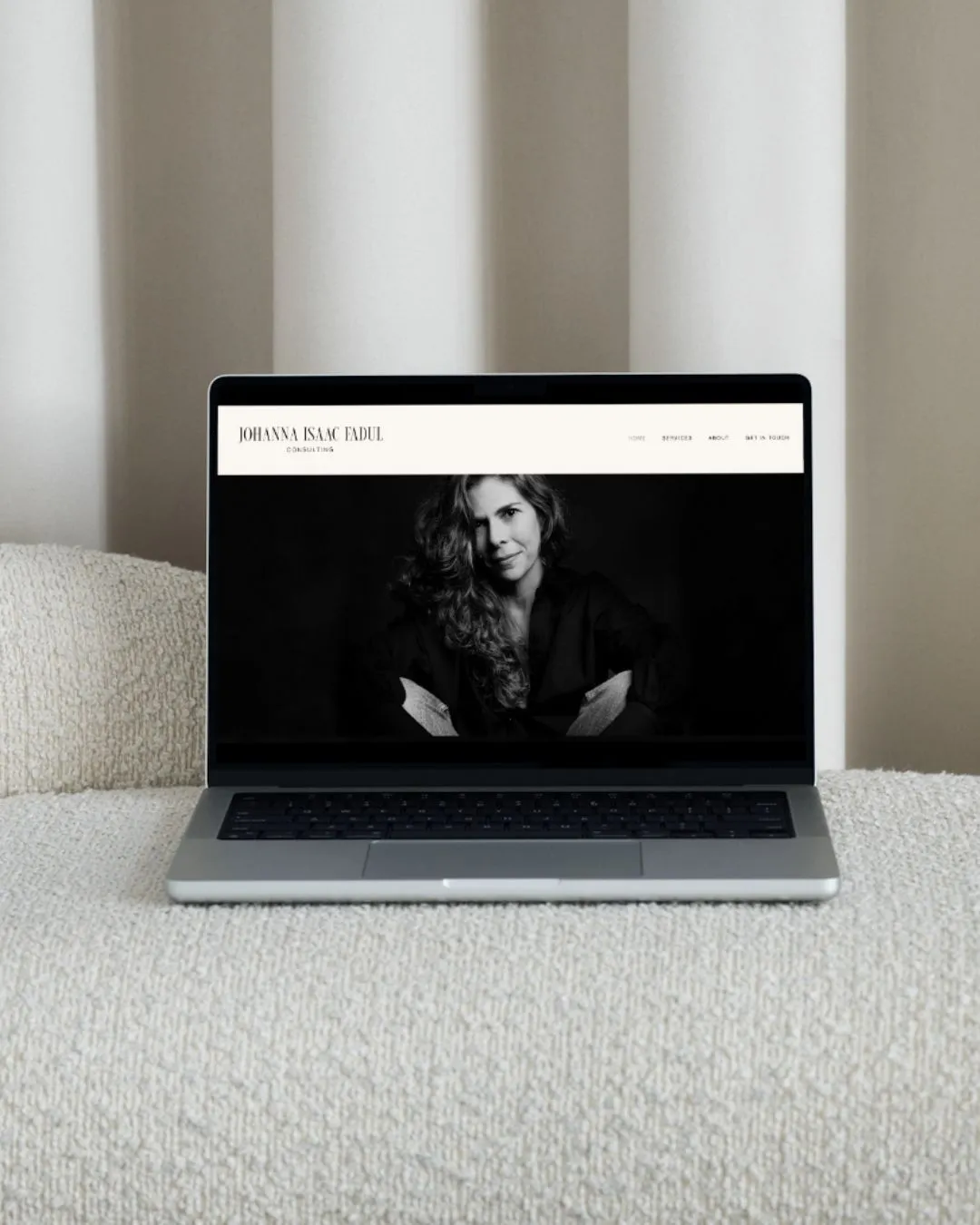 Johanna Isaac website with a black-and-white portrait on a laptop