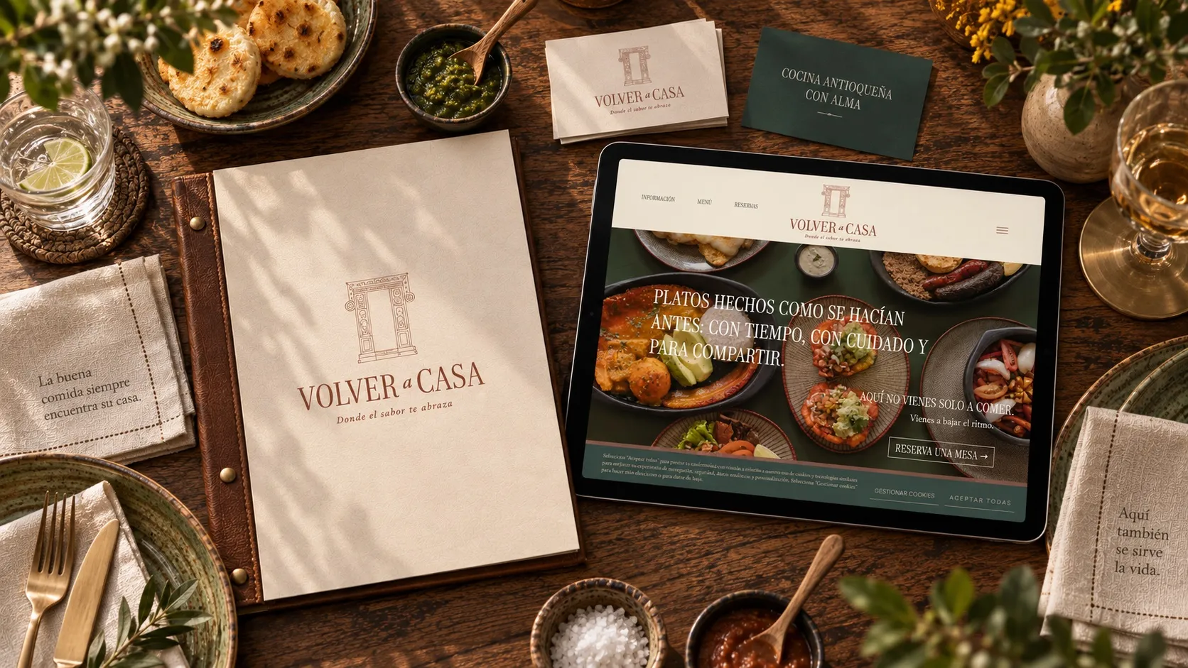 Volver a Casa menu, stationery and tablet with the website