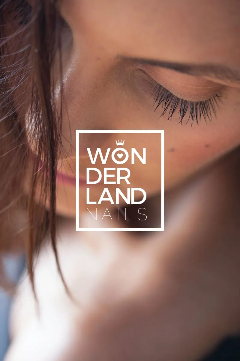 Wonderland Nails logo over the portrait of a woman with closed eyes
